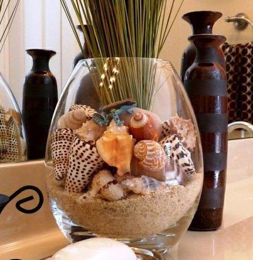 Jarrón de cristal decorado con arena de sílice, conchas y caracolas naturales. Una idea sencilla y elegante para aportar un toque mediterráneo y veraniego a cualquier rincón del hogar.